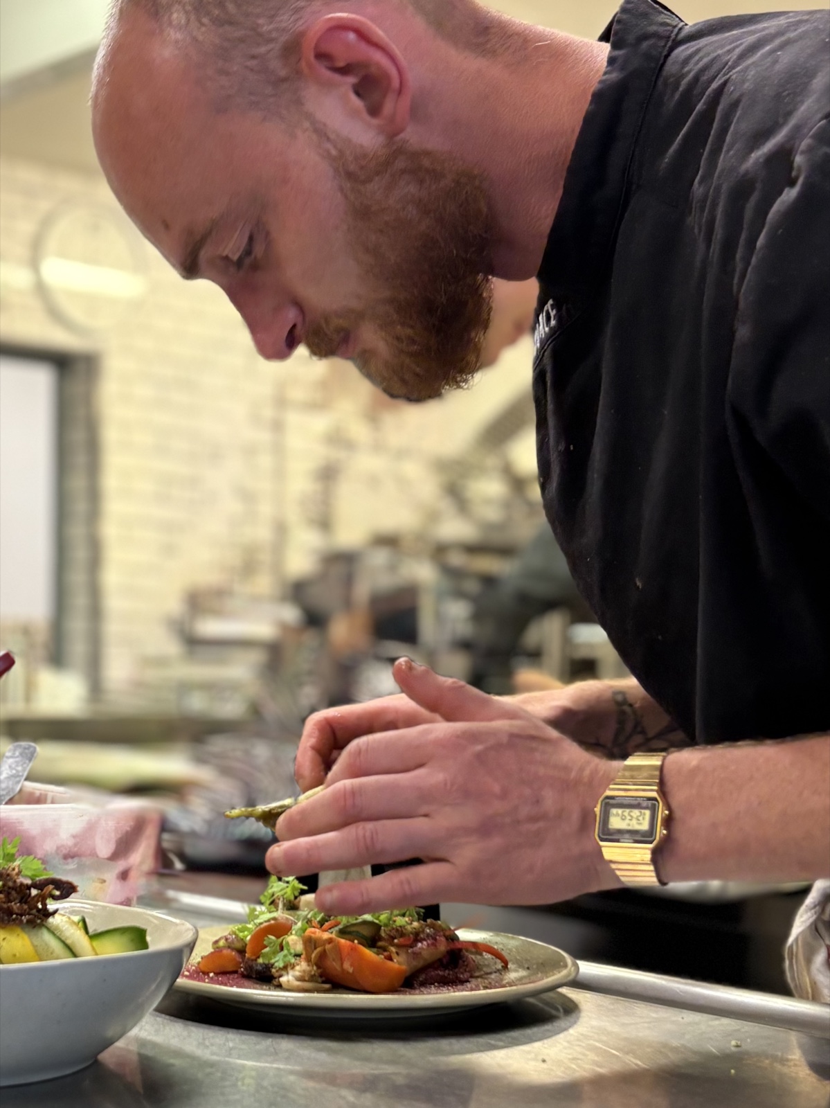 Nicolas en cuisine, en train de dresser une assiette